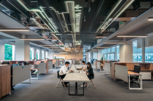 Salle de travail entreprise avec employés devant leur ordinateur